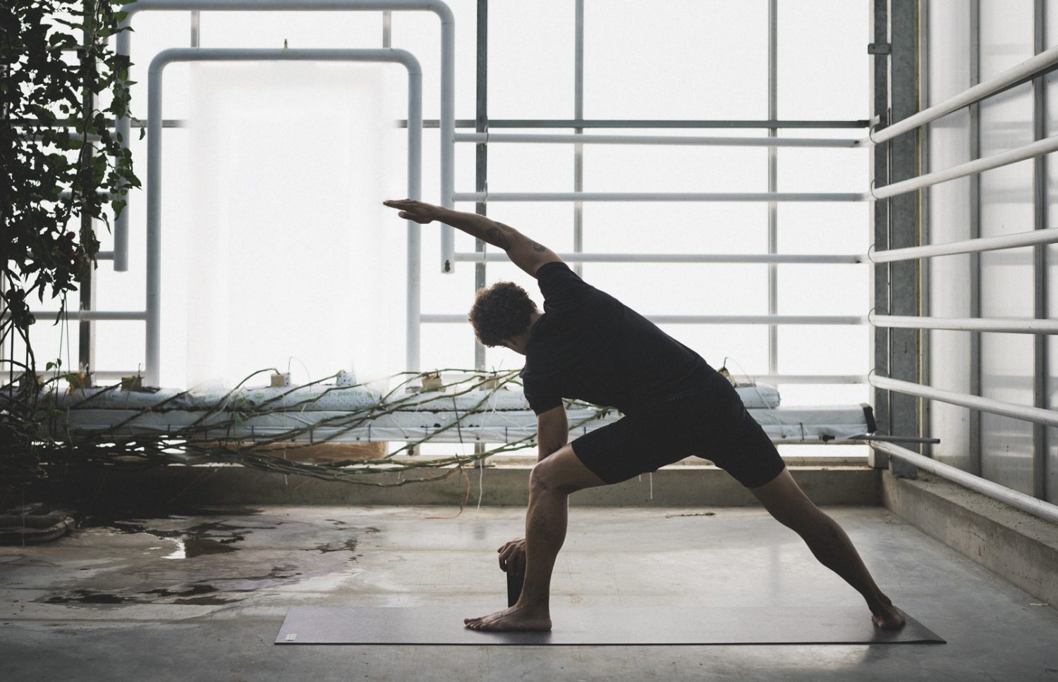 Dreieck oder Trikonasana von einem Mann mit einem Yoga Block - hast du noch Vorurteile über Yoga Zubehör?
