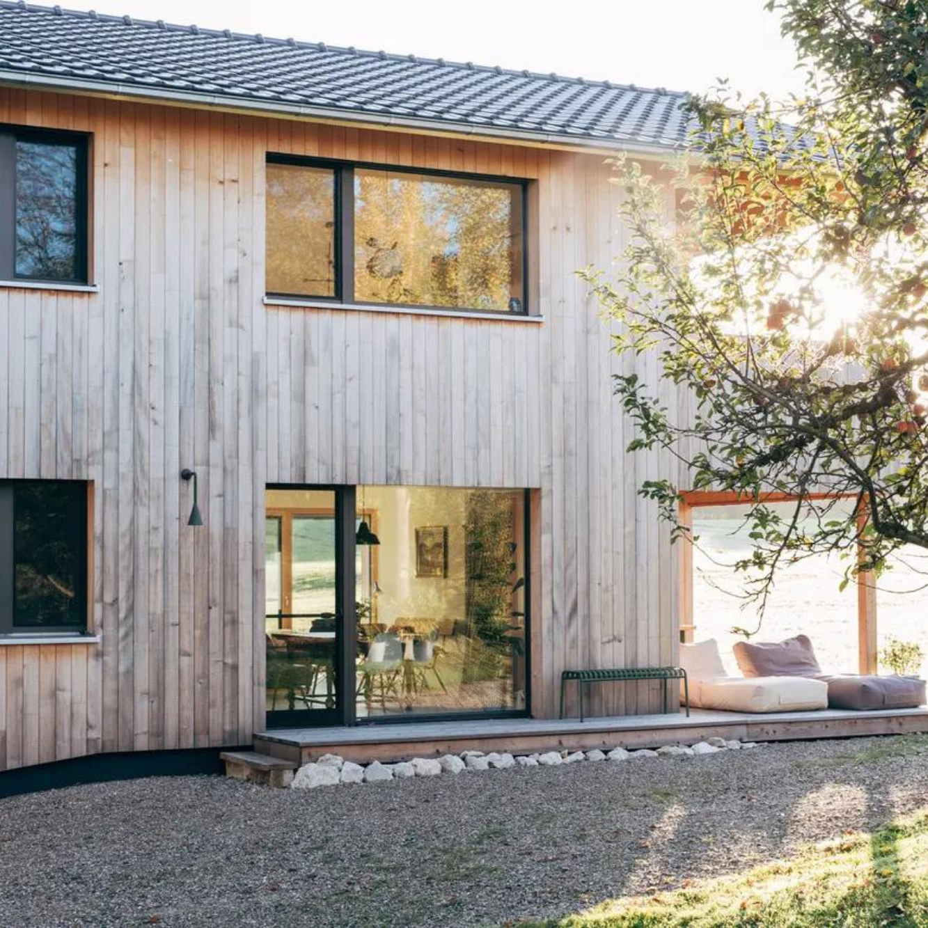 Ein modernes Holzhaus mit sehr großen Fenstern und viel Licht