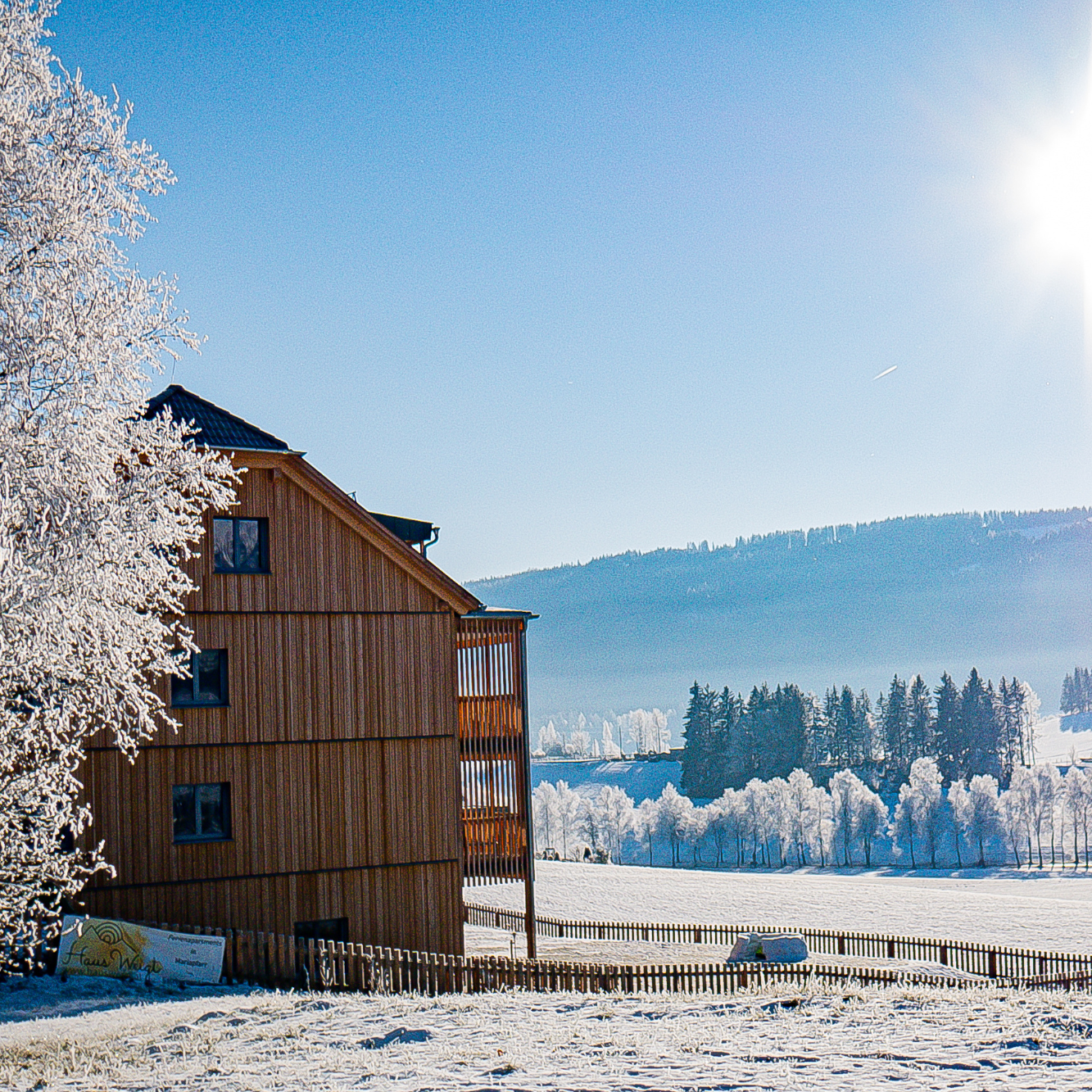 Ein Holzhaus mitten in einer verschneiten Landschaft
