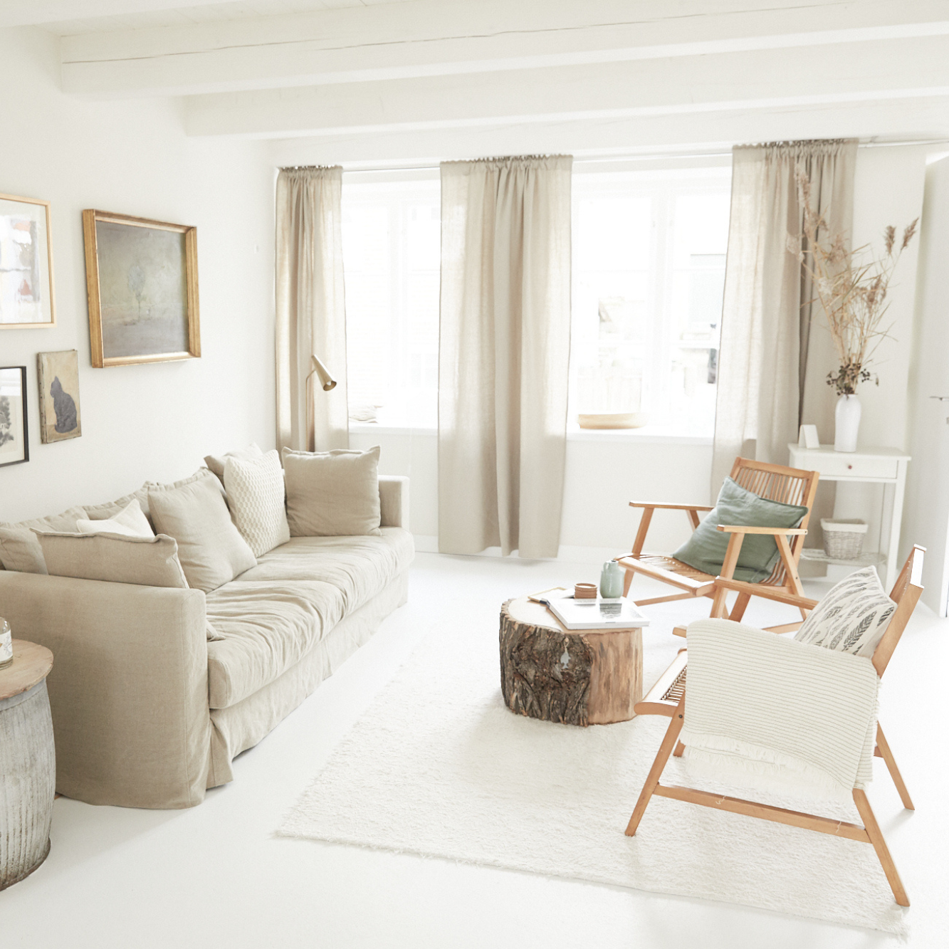 Ganz in weiß eingerichtetes Wohnzimmer mit einer gemütlichen Couch