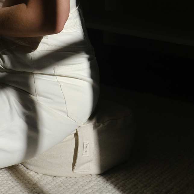 Eine Frau sitzt im Meditationskissen