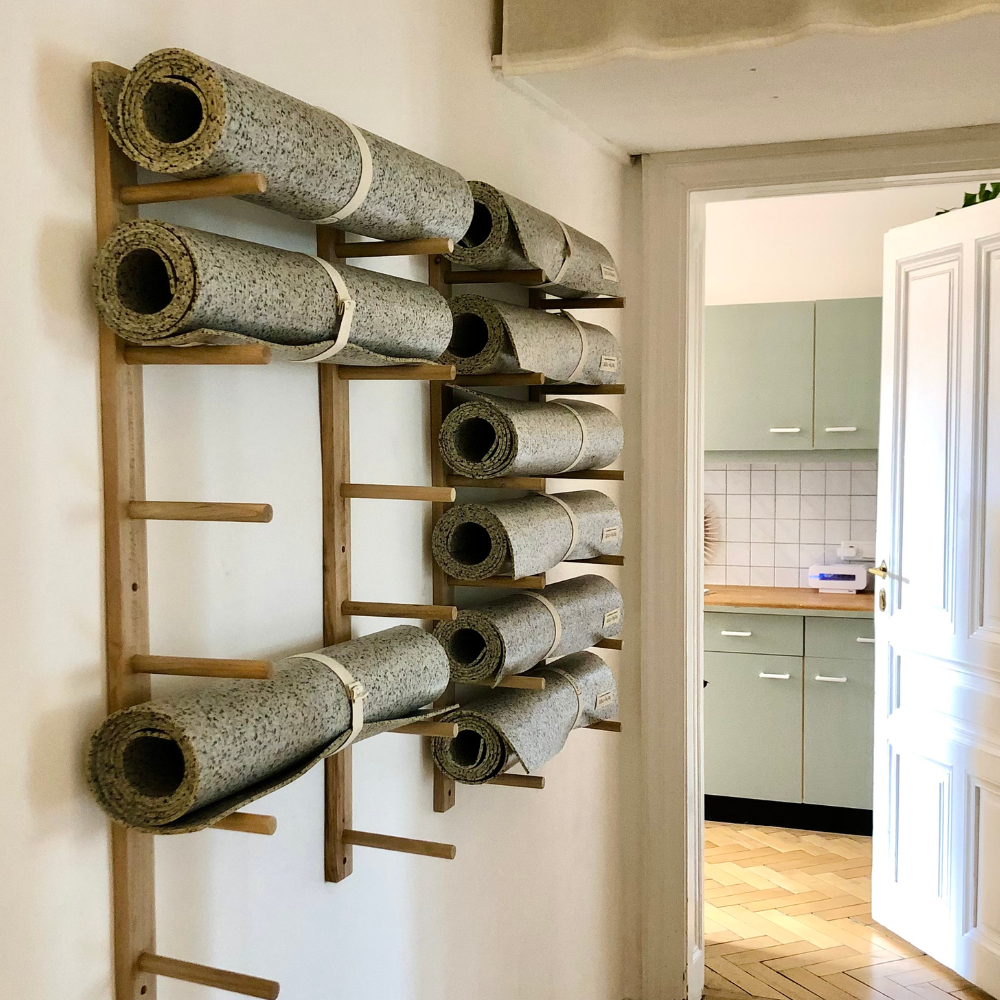 Die Yogamatten hängen an einem selbstgebauten Regal im Studio in Wien