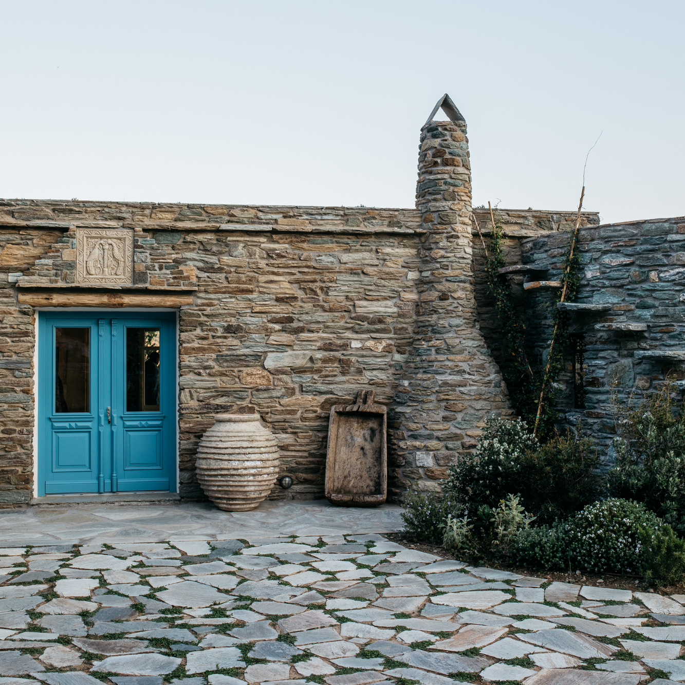 Ein Haus komplett aus Steinen mit einer blauen Tür
