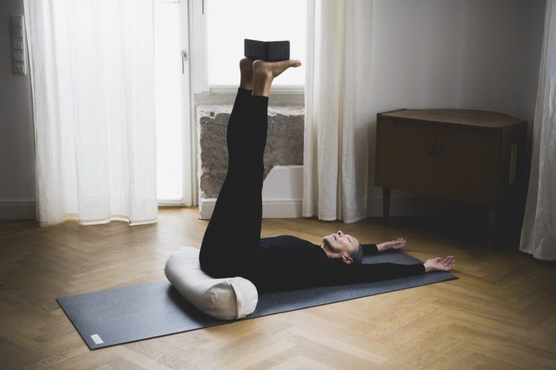 supported shoulderstand with the back on the hejhej-bolster and the hands over the head
