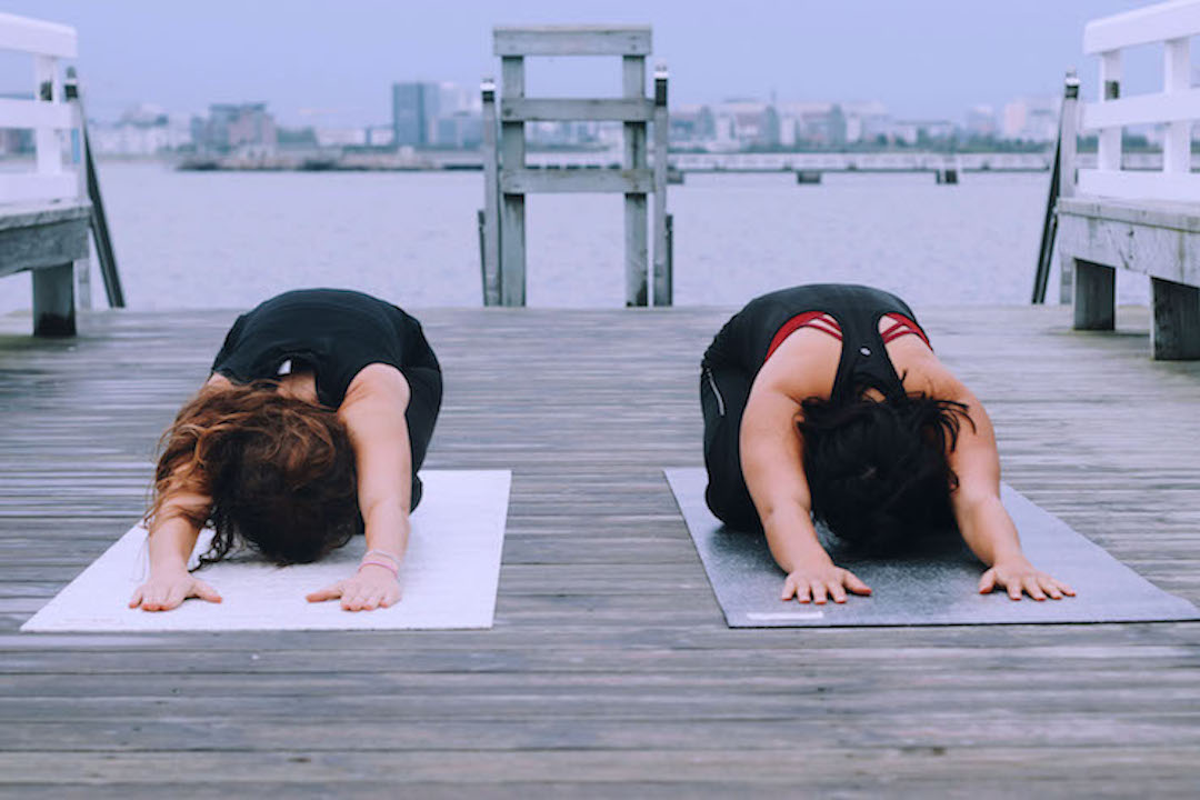 Zwei Mädchen in der Childs Pose als Beispiel für viele Vorteile von Yoga
