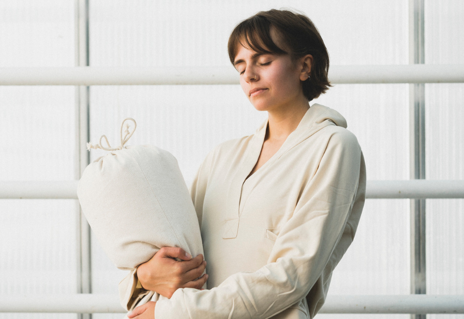 eine Frau trägt den Yoga Bolster - er kann ein super nachhaltiges Weihnachtsgeschenk für Yoga sein