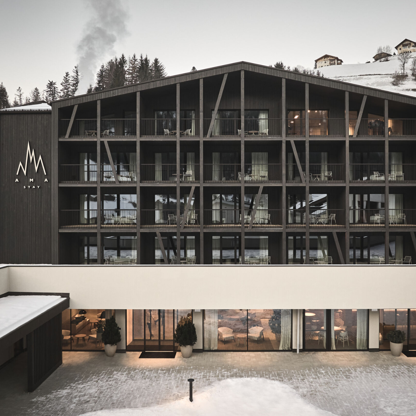 Ein modernes Hotel mit schwarzer Holzfassade und vielen Balkonen