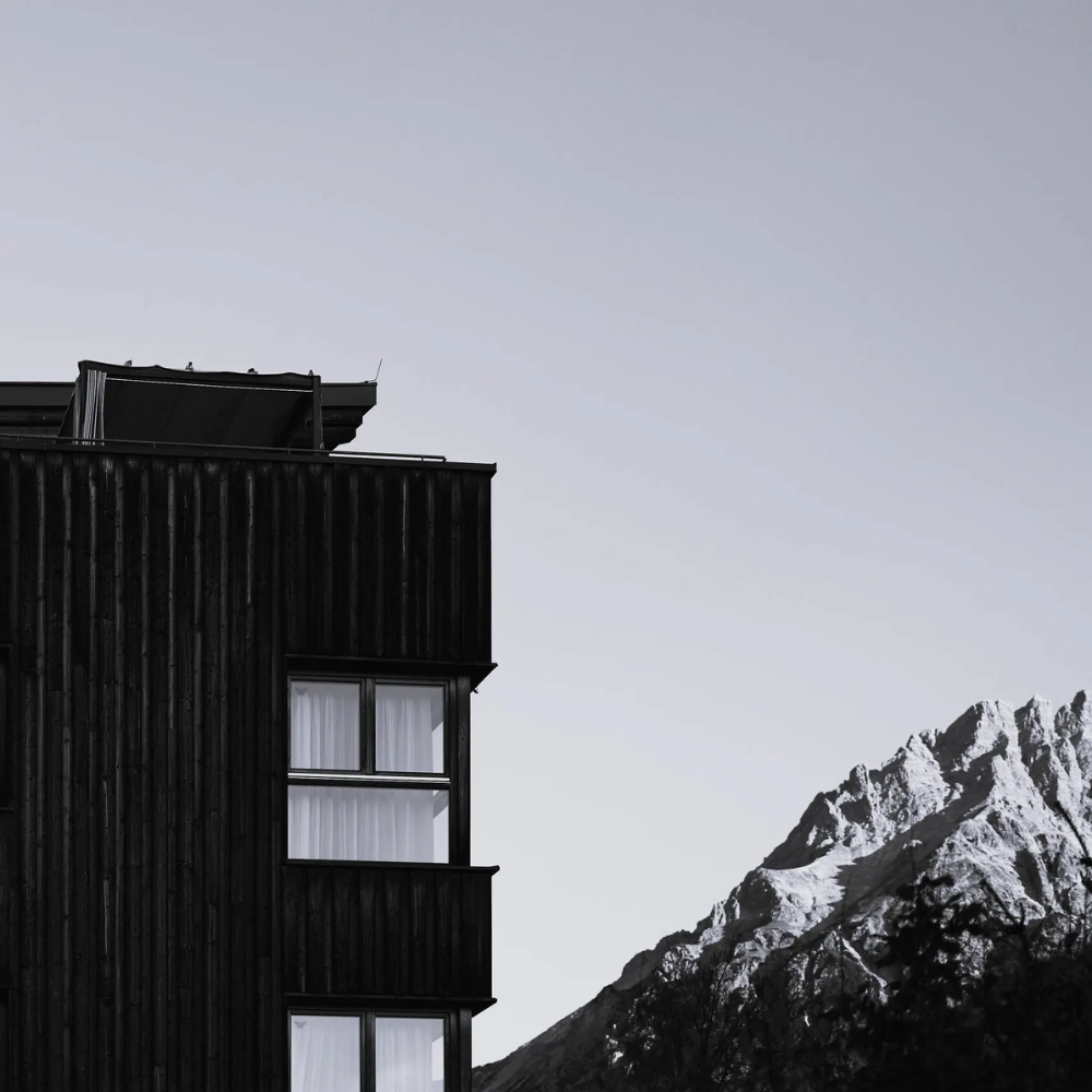 das Holzhotel umgeben von der Natur und hohen schneebedeckten Bergen