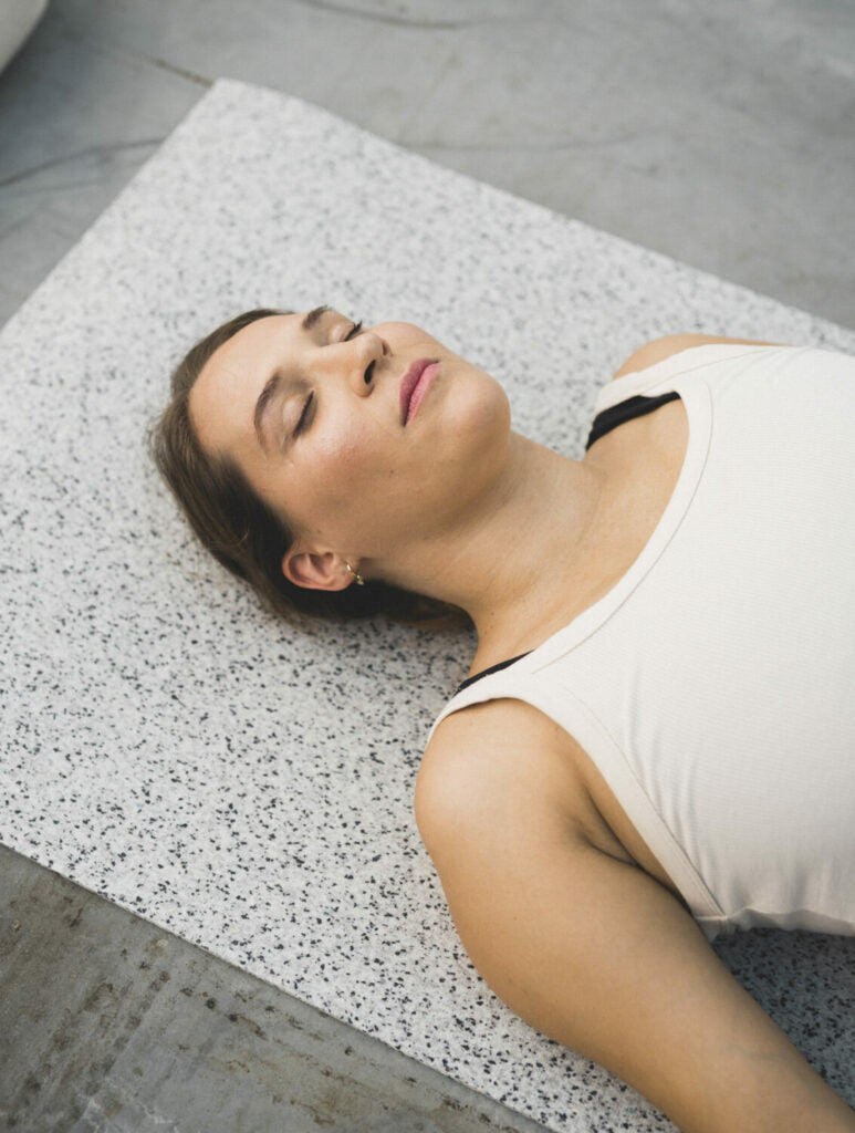 Woman lying on the light hejhej-mat with a very relaxed face