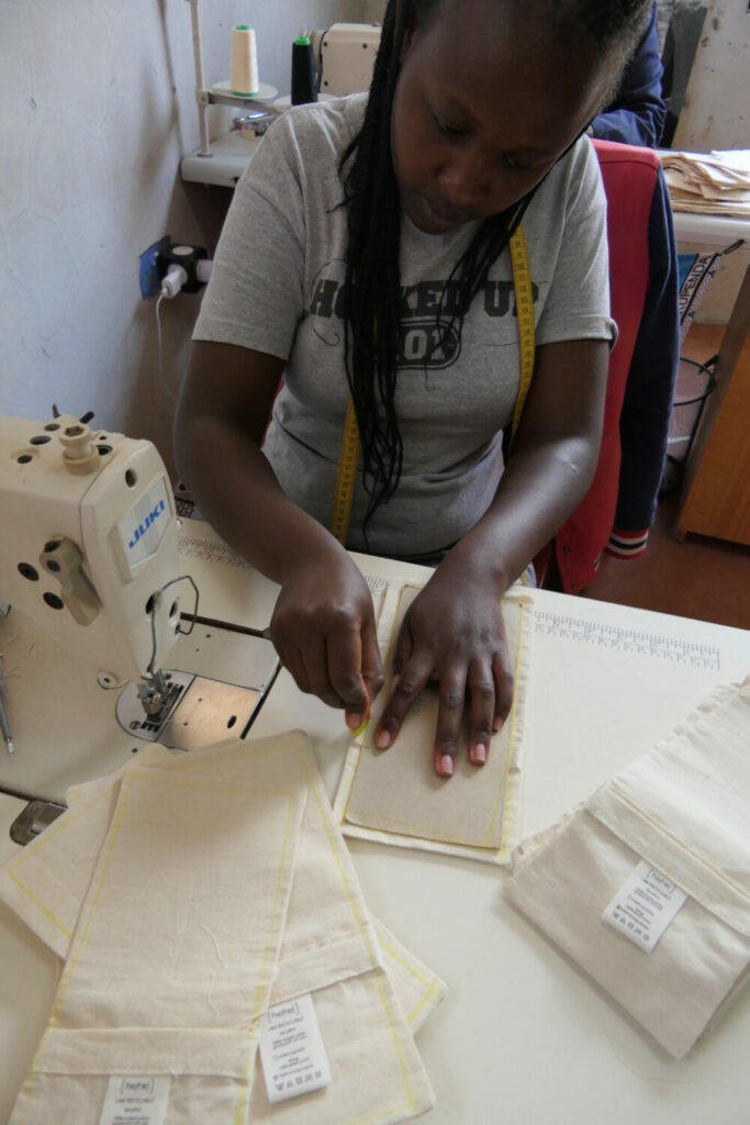 A Kenyan seamstress sews the cover of the sustainable eye pillow