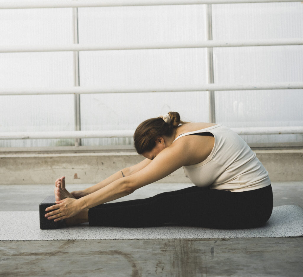 Try these stretches with a yoga block in a seated forward bend.