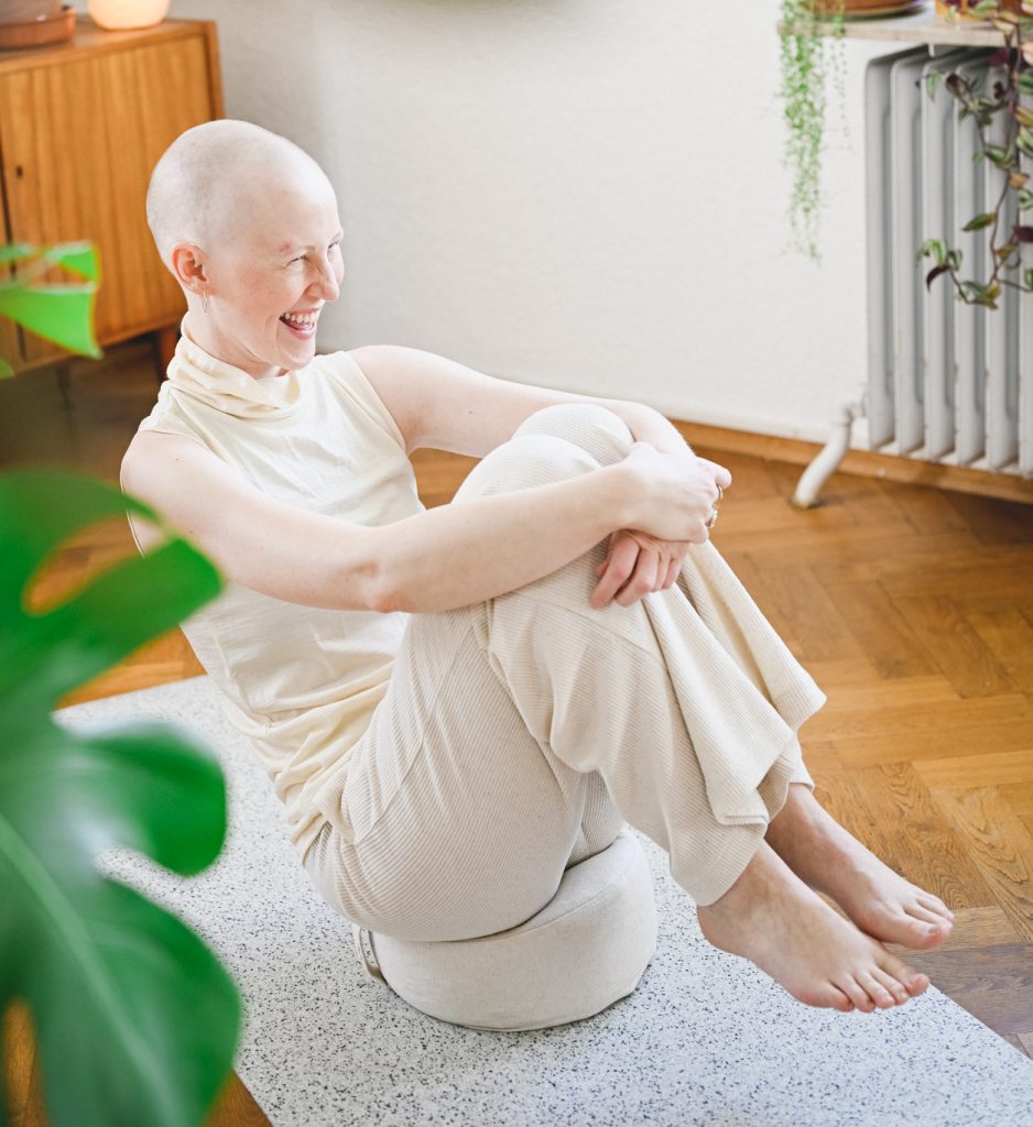 Frau balanciert lachend auf dem hejhej Meditationskissen